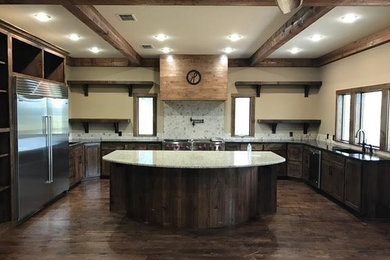 Inspiration for a large rustic u-shaped dark wood floor eat-in kitchen remodel in New Orleans with an island, recessed-panel cabinets, dark wood cabinets, an undermount sink, terrazzo countertops, multicolored backsplash, stone slab backsplash and stainless steel appliances