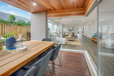 This is an example of a contemporary backyard deck in Brisbane with a roof extension.