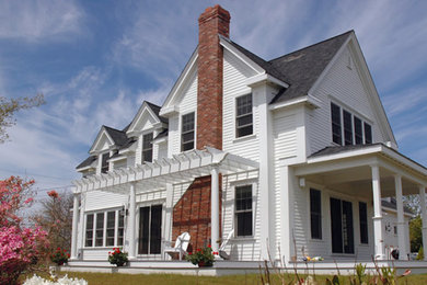 Large farmhouse white two-story wood exterior home photo in Boston with a shingle roof
