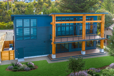 Trendy blue two-story house exterior photo in Seattle with a shed roof and a metal roof