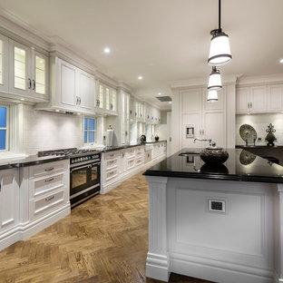 Huge traditional kitchen pantry appliance - Kitchen pantry - huge traditional galley dark wood floor kitchen pantry idea in Perth with an undermount sink, recessed-panel cabinets, beige cabinets, granite countertops, white backsplash, ceramic backsplash, stainless steel appliances and an island