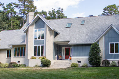 Inspiration for a large 1960s blue concrete fiberboard and board and batten house exterior remodel in Raleigh