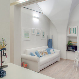 Mediterranean open plan living room in Other with white walls, laminate floors and a wall mounted tv.
