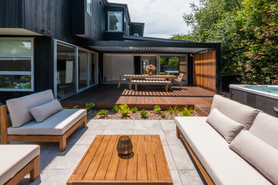 Modelo de terraza contemporánea en patio con pérgola y barandilla de metal