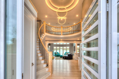 Design ideas for a large modern carpeted curved staircase in Other with carpet risers and wood railing.
