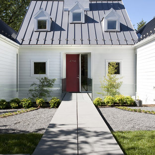 Exempel på ett stort klassiskt vitt hus, med allt i ett plan, sadeltak, tak i metall och vinylfasad