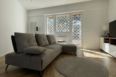 Esempio di un grande soggiorno minimal aperto con pareti bianche, pavimento in gres porcellanato e TV a parete
