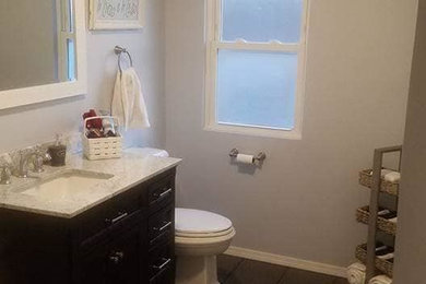 Example of a 3/4 brown floor corner shower design in Chicago with brown cabinets, gray walls and granite countertops
