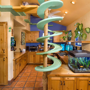 Inspiration for an eclectic home office in Santa Barbara with beige walls and terra-cotta floors.