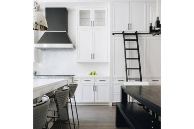 Inspiration for a contemporary dark wood floor kitchen remodel in Chicago with white cabinets, white backsplash, stainless steel appliances, an island and white countertops