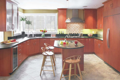 Example of a mid-sized minimalist u-shaped terra-cotta tile enclosed kitchen design in Boston with an undermount sink, red cabinets, flat-panel cabinets, granite countertops, beige backsplash, ceramic backsplash, paneled appliances and an island