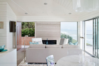 Example of a mid-sized beach style open concept living room design in San Diego with white walls and a wall-mounted tv