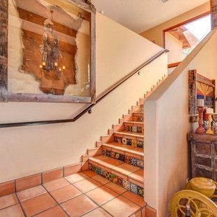 Modelo de escalera en L, de estilo americano, grande, con escalones de terracota, contrahuellas de terracota y barandilla de metal