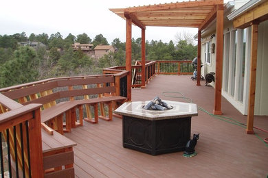 Large traditional backyard deck in Denver with a pergola.