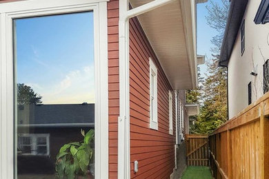 Inspiration for a mid-sized farmhouse red one-story wood exterior home remodel in Other with a shingle roof