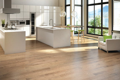 Example of a large minimalist light wood floor open concept kitchen design in Vancouver with a double-bowl sink, flat-panel cabinets, white cabinets, stainless steel appliances and two islands