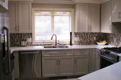 Example of a small arts and crafts u-shaped marble floor eat-in kitchen design in Other with an undermount sink, shaker cabinets, beige cabinets, quartz countertops, brown backsplash, stone tile backsplash, stainless steel appliances and a peninsula