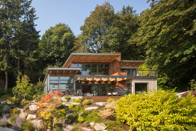Design ideas for a large modern two-storey brown house exterior in Seattle with a flat roof.