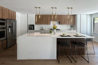 Kitchen - large modern single-wall medium tone wood floor kitchen idea in San Diego with a single-bowl sink, flat-panel cabinets, quartz countertops, white backsplash, quartz backsplash, stainless steel appliances, an island and white countertops