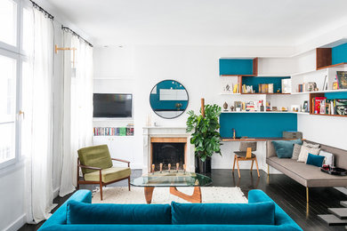 Aménagement d'un salon contemporain de taille moyenne et ouvert avec une bibliothèque ou un coin lecture, un mur bleu, parquet peint, une cheminée standard, un manteau de cheminée en pierre, un téléviseur fixé au mur et un sol noir.