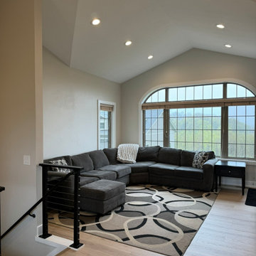Living Room with Vaulted Ceiling, Arched Window, and Black Cable Railing