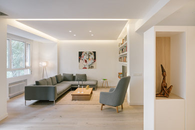 Inspiration for a mid-sized scandinavian formal open concept living room in Madrid with white walls, light hardwood floors and a freestanding tv.