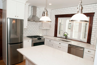 Inspiration for a timeless medium tone wood floor kitchen remodel in Boston with a single-bowl sink, shaker cabinets, white cabinets, quartzite countertops, subway tile backsplash and stainless steel appliances