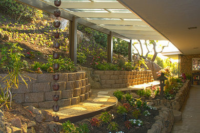 Inspiration for a mid-sized traditional backyard partial sun formal garden in San Diego with a retaining wall.