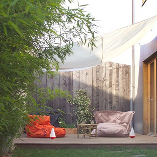Mittelgroßer Moderner Patio neben dem Haus mit Dielen und Markisen in Lyon