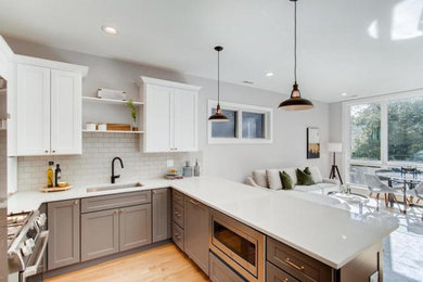 Inspiration for a small timeless galley open concept kitchen remodel in Chicago with an undermount sink, flat-panel cabinets, white cabinets, gray backsplash, stainless steel appliances, a peninsula and white countertops