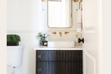 Photo of a transitional powder room in Chicago with furniture-like cabinets, black cabinets, white walls, marble floors, a vessel sink, grey floor and white benchtops.