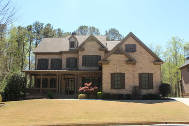 Large elegant brown two-story brick exterior home photo in Atlanta with a shingle roof