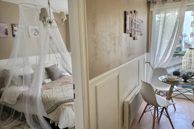 Réalisation d'une chambre parentale beige et blanche tradition de taille moyenne avec un mur beige, aucune cheminée, un sol marron et du papier peint.