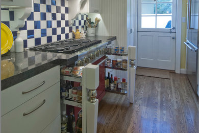 Example of a mid-sized classic u-shaped light wood floor eat-in kitchen design in Los Angeles with a single-bowl sink, shaker cabinets, white cabinets, quartzite countertops, black backsplash, ceramic backsplash, colored appliances and no island