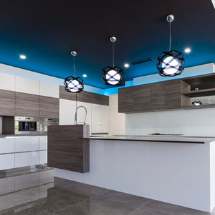 Modern kitchen pantry appliance - Example of a minimalist galley ceramic floor kitchen pantry design in Gold Coast - Tweed with an undermount sink, recessed-panel cabinets, white cabinets, stainless steel appliances and an island