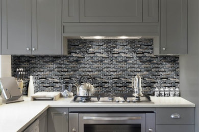 Trendy kitchen photo in Miami with multicolored backsplash, mosaic tile backsplash, shaker cabinets, gray cabinets, quartz countertops and stainless steel appliances