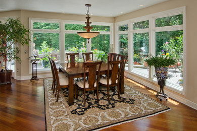 Example of a mid-sized classic medium tone wood floor great room design in Other with beige walls and no fireplace