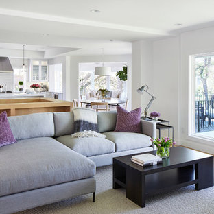 Idéer för att renovera ett mellanstort funkis allrum med öppen planlösning, med vita väggar, ljust trägolv, en väggmonterad TV, en dubbelsidig öppen spis, en spiselkrans i gips och beiget golv