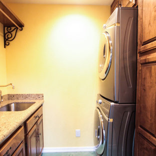 サンフランシスコの小さいトラディショナルスタイルのおしゃれな洗濯室 (上下配置の洗濯機・乾燥機、アンダーカウンターシンク、シェーカースタイル扉のキャビネット、中間色木目調キャビネット、御影石カウンター、ベージュの壁、コンクリートの床、緑の床) の写真