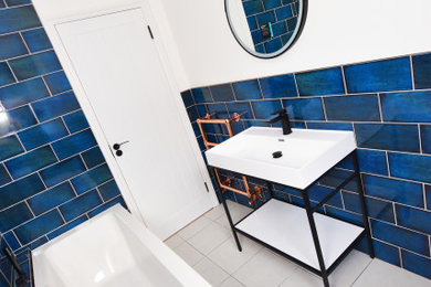 Inspiration for a small bathroom in London with black cabinets, blue tiles, ceramic tiles, ceramic flooring, white floors and a single sink.