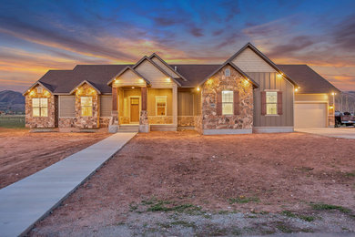 Mid-sized mountain style brown two-story stucco exterior home photo in Salt Lake City with a shingle roof