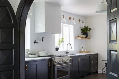 Inspiration for a mid-sized country galley dark wood floor and brown floor enclosed kitchen remodel in Other with an undermount sink, shaker cabinets, black cabinets, marble countertops, white backsplash, subway tile backsplash, black appliances, no island and white countertops