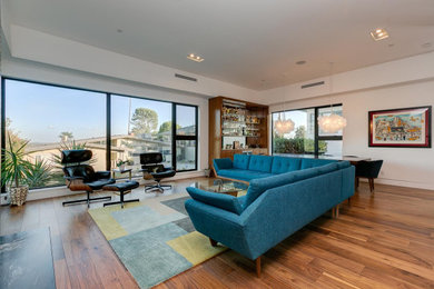 Open concept brown floor living room photo in Los Angeles with white walls