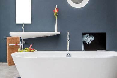 Réalisation d'une salle de bain design de taille moyenne avec une baignoire indépendante, un mur noir et un lavabo suspendu.