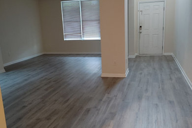 Ejemplo de salón abierto extra grande con suelo vinílico y suelo gris