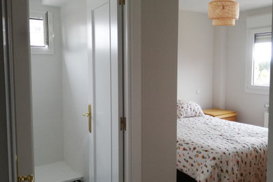 Ejemplo de dormitorio principal escandinavo de tamaño medio sin chimenea con paredes blancas y suelo de madera en tonos medios