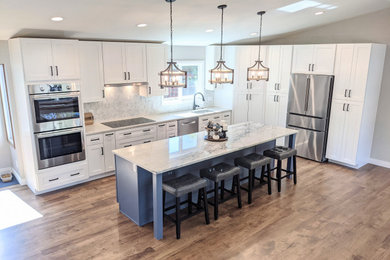 Kitchen - huge transitional l-shaped medium tone wood floor and brown floor kitchen idea in Denver with an undermount sink, shaker cabinets, white cabinets, quartzite countertops, marble backsplash, stainless steel appliances, an island and white countertops