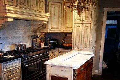 Inspiration for a mid-sized country u-shaped dark wood floor and brown floor eat-in kitchen remodel in San Francisco with raised-panel cabinets, distressed cabinets, marble countertops, gray backsplash, stainless steel appliances and an island