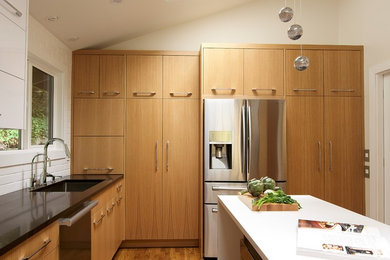 Inspiration for a small modern l-shaped light wood floor and brown floor enclosed kitchen remodel in Seattle with a single-bowl sink, flat-panel cabinets, light wood cabinets, quartz countertops, white backsplash, ceramic backsplash, stainless steel appliances and an island