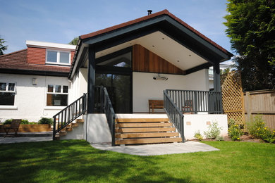 Photo of a mid-sized contemporary one-storey stucco white house exterior in Glasgow with a gable roof and a tile roof.